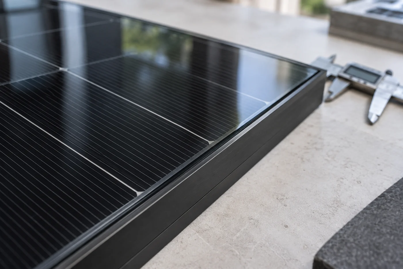 Detail eines Solarmoduls mit schwarzen Zellen und Glasoberfläche