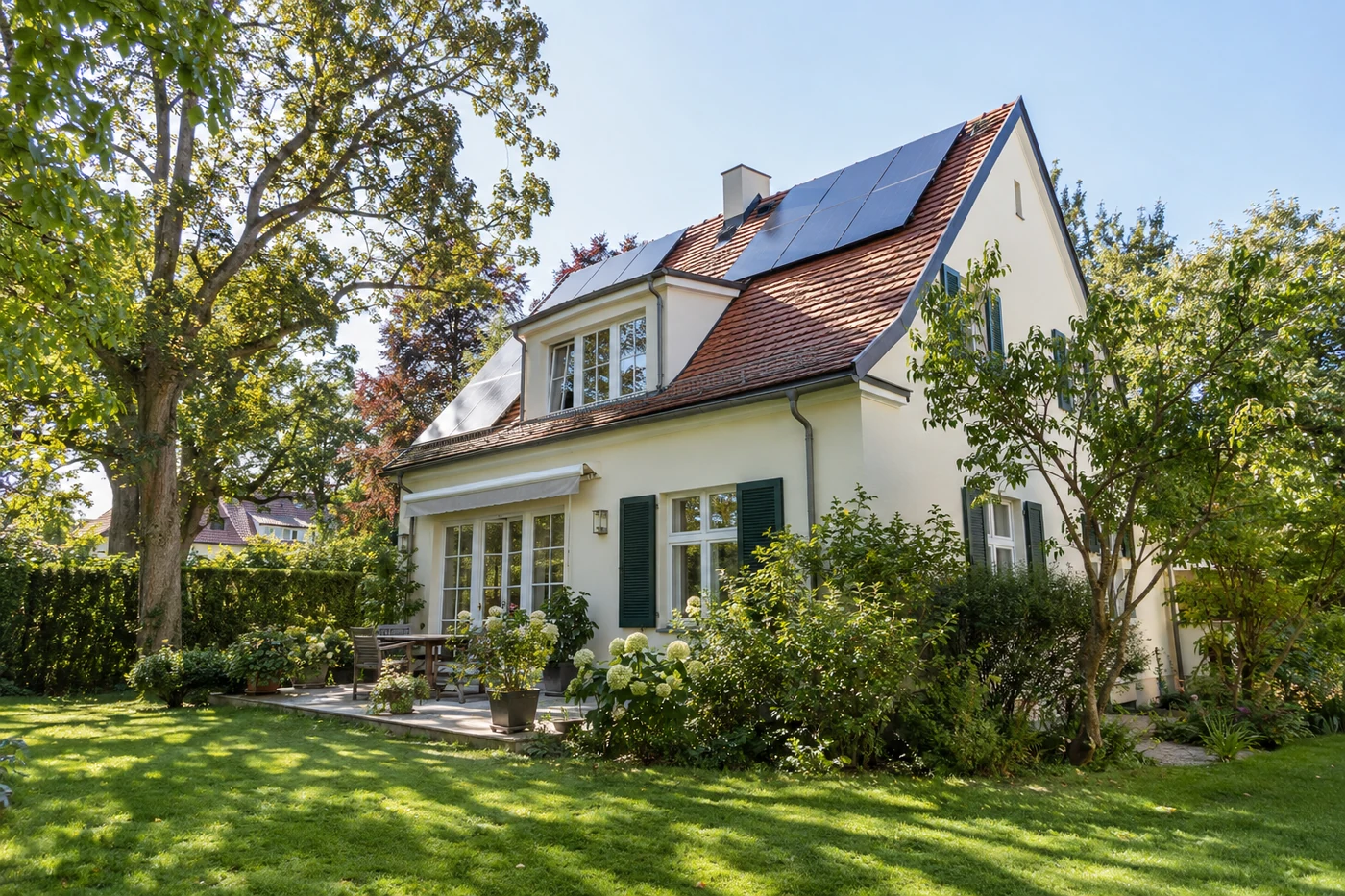 Villa mit Solarmodulen und alten Gartenbäumen