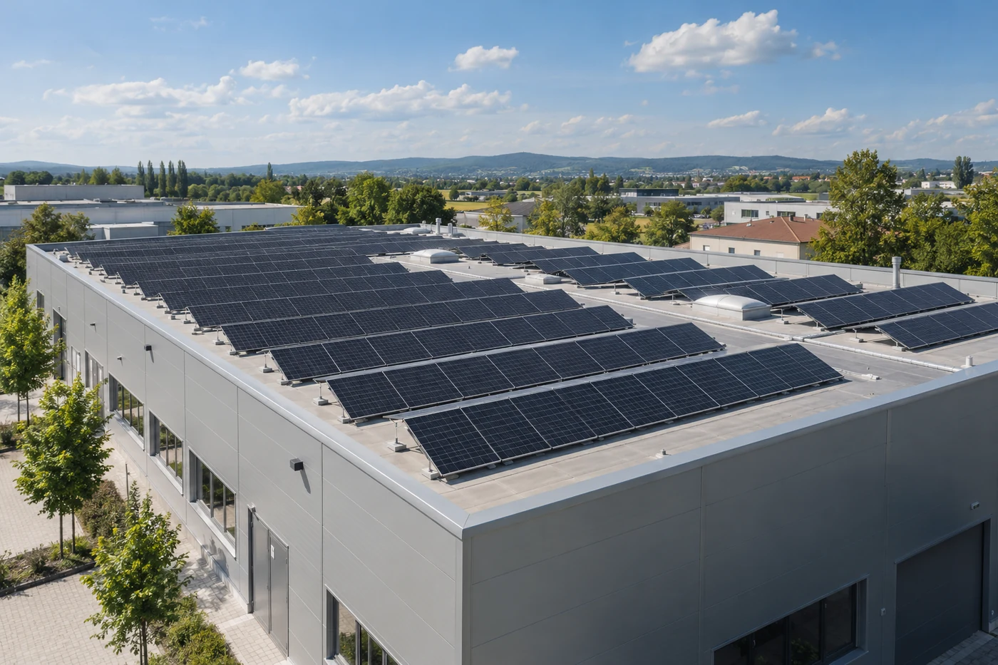 Photovoltaikmodule auf dem Flachdach eines niedrigen Gewerbegebäudes