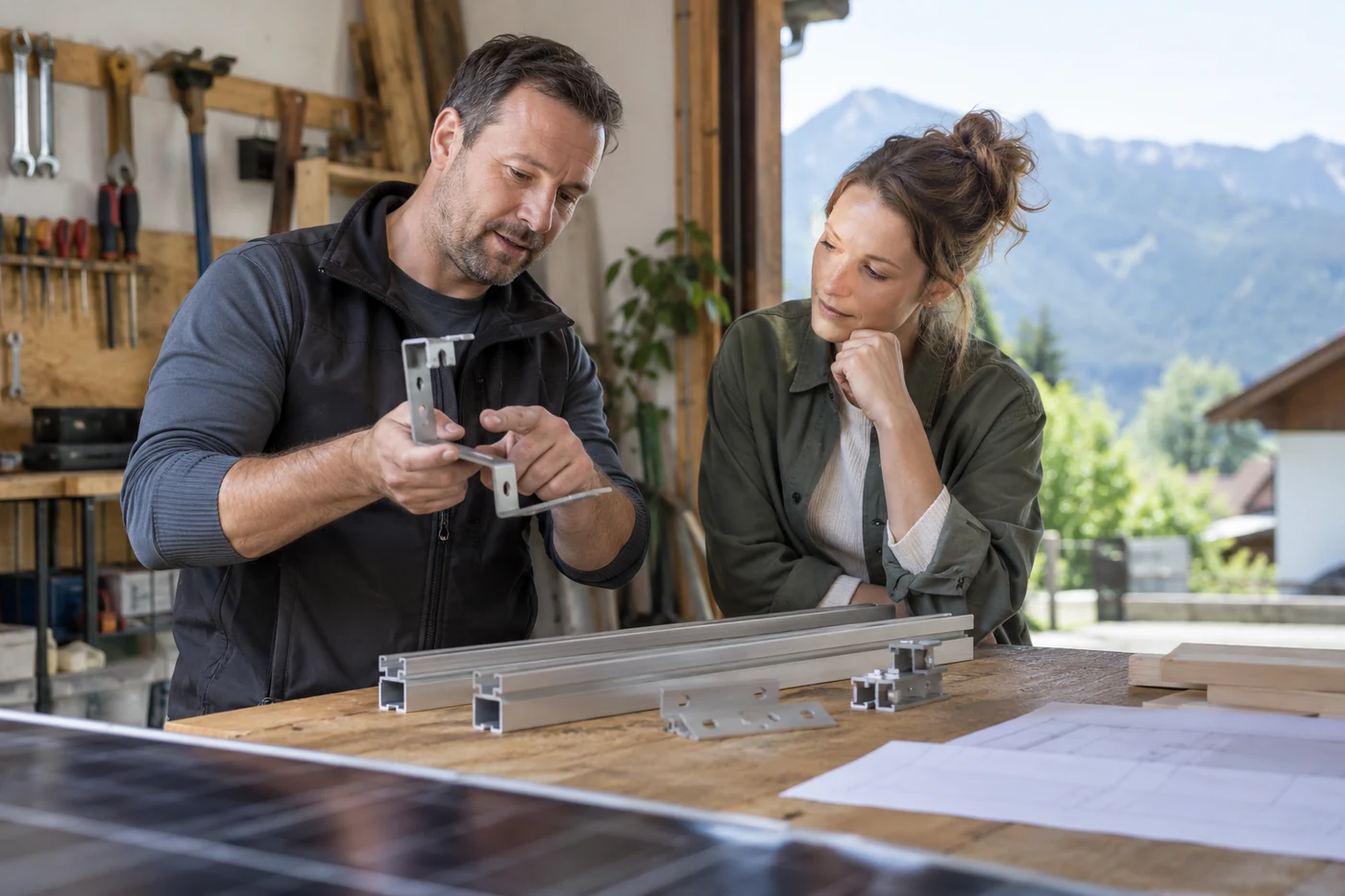Zwei Personen besprechen Montagebauteile an einer Werkbank
