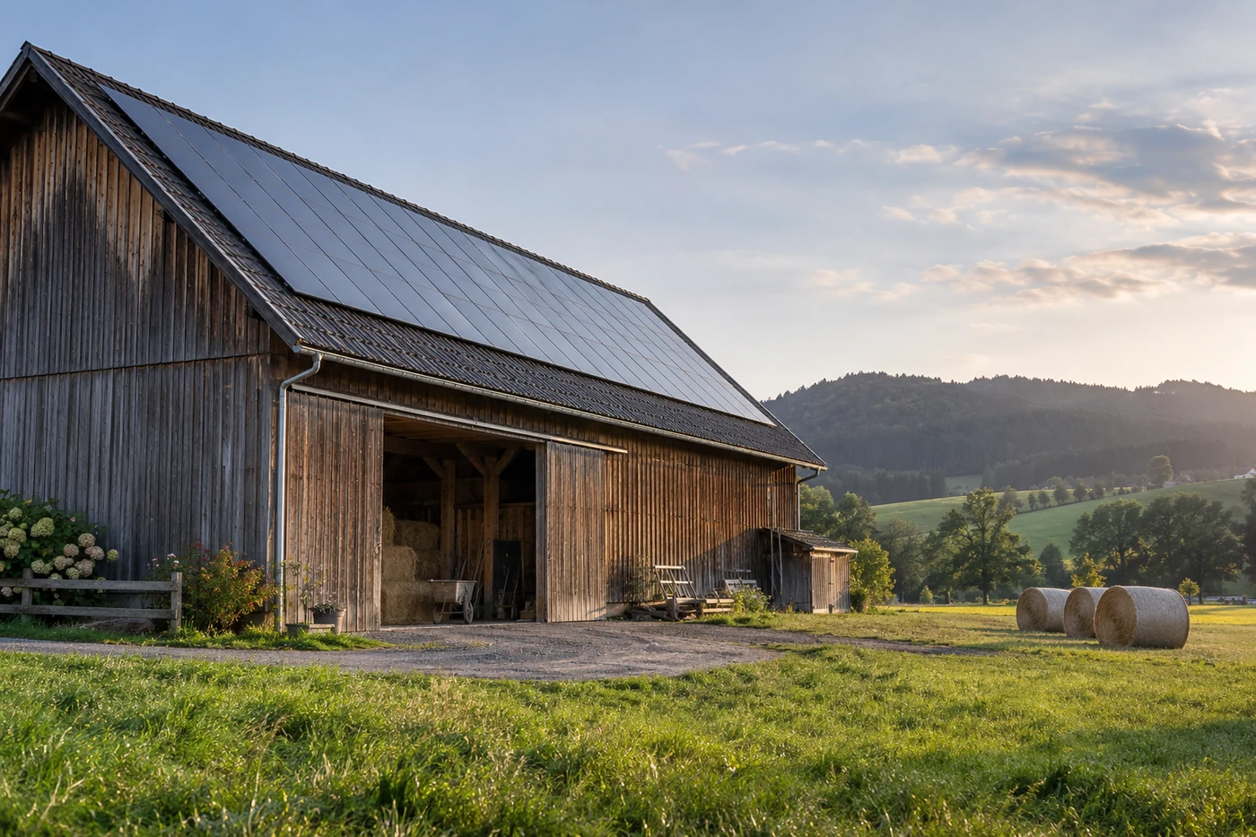 Scheune mit Solarmodulen neben einer grünen Wiese
